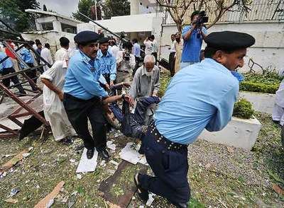 Policías paquistaníes retiran el cuerpo de una de las víctimas del atentado de ayer contra la embajada danesa en Islamabad