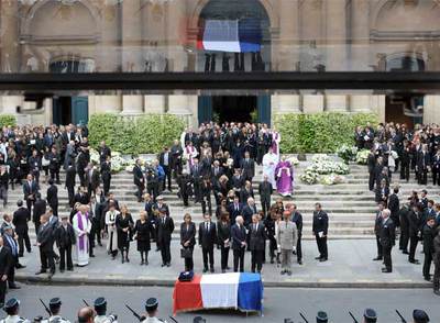 El ataúd con los restos de Yves Saint Laurent, ante Nicolas Sarkozy y su esposa, a la puerta de la iglesia de Saint-Roch de París.