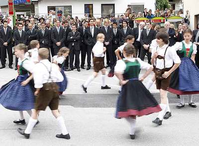 Unos niños bailan ante la delegación española a su llegada a Neustift.