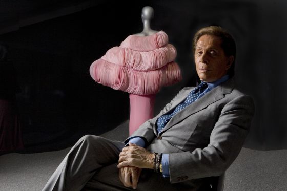 El modisto Valentino, posa delante de uno de sus últimos diseños a la entrada de su exposición retrospectiva  en el Museo de Artes Decorativos del Louvre en París.