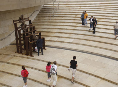 Un grupo de visitantes bajaba ayer por las escaleras del acceso principal al Museo Guggenheim Bilbao, donde está instalado un grupo escultórico de Juan Muñoz.