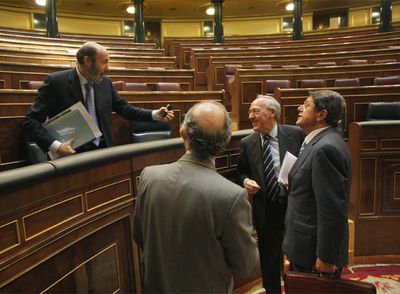 El ministro del Interior, Pérez Rubalcaba, conversa desde su escaño con los diputados populares Montoro, Pizarro y Trillo.