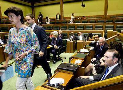 María San Gil pasa por delante del  lehendakari,  Juan José Ibarretxe, durante el pleno del Parlamento vasco.