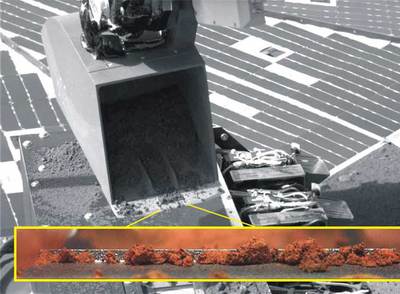 La pala de la  Phoenix  vierte una muestra de suelo de Marte para su análisis. Imagen de la tierra cogida.