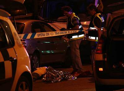 Dos policías observan el cadáver de Jonathan Darío Medina Martínez.