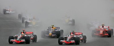 Los McLaren de Hamilton (izquierda) y Kovalainen (derecha) lideran la carrera por delante de Webber y Raikkonen en la primera curva, después de la salida.