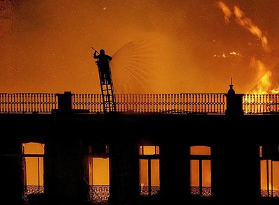 Un bombero hace frente a las llamas que destruyen un edificio en el centro de Lisboa.