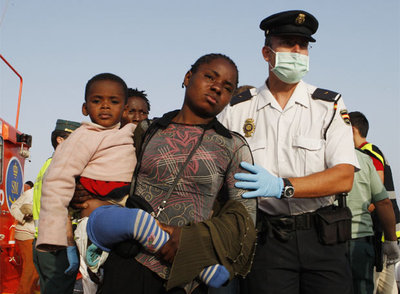 Un policía atiende a una inmigrante con su bebé tras su llegada al puerto de Motril (Granada).