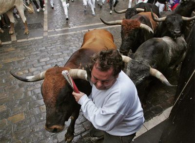 Un mozo corre ante los  miuras en la curva de Mercaderes.