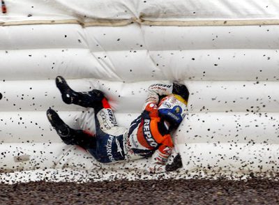 Dani Pedrosa se golpea contra la lona de protección después de caer de su moto cuando iba líder del Gran Premio de Alemania.