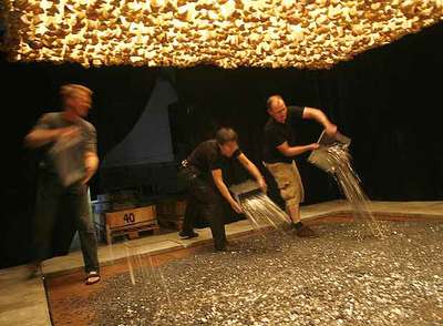 Personal de la colección Daros daba ayer forma a la instalación  MissãoMissões  de Cildo Meireles, lanzando 600.000 monedas.