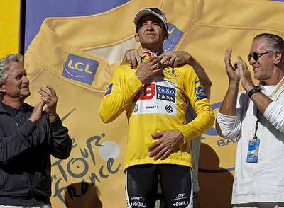 Sastre recibe el  maillot  amarillo entre los aplausos del actor Michael Douglas, a la izquierda, y Pat Riley, presidente de los Miami Heat.