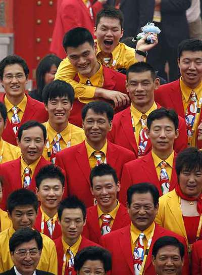 El baloncestista Yao Ming, arriba, es  abrazado por un compañero en la apertura de la Villa Olímpica.