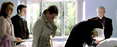 Fotograma de uno de los momentos clave de  Camino:  la muerte de la niña en un hospital, junto a sus familiares y sacerdotes del Opus Dei.