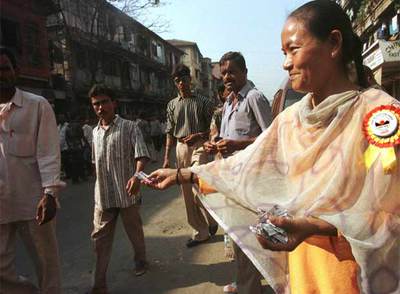 Una ex prostituta reparte condones en un barrio de Bombay para prevenir el sida.