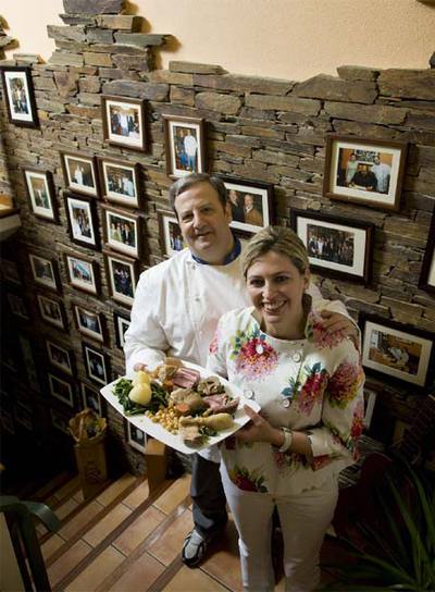 José Luis Iglesias y Áurea Vázquez, delante de la pared con fotografías de su restaurante.