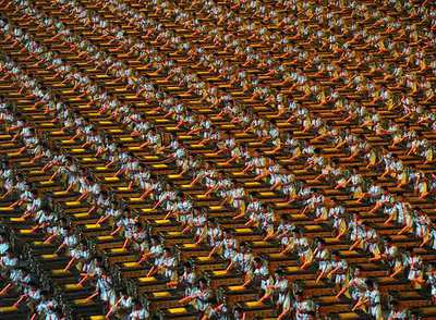 Cientos de chinos realizan el mismo movimiento de percusión durante la ceremonia de apertura.