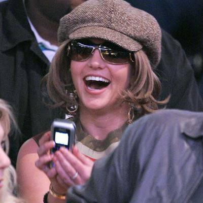 Britney Spears juega con su móvil en un partido de baloncesto en Los Ángeles.