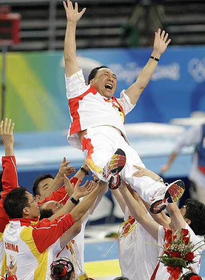 Los entrenadores chinos mantean a su responsable.