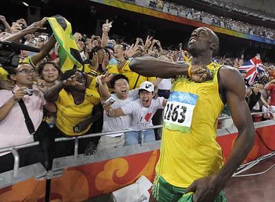 Usain Bolt, ante la afición jamaicana, se golpea el pecho para celebrar su victoria.