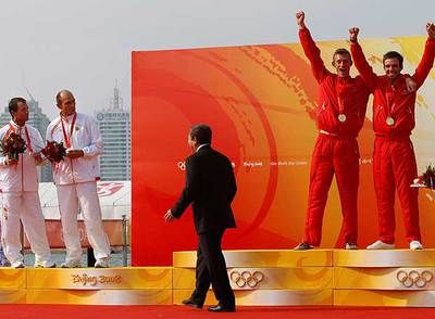 Iker Martínez y Xabi Fernández, a la izquierda, observan con la medalla de plata cómo los daneses celebran la de oro.