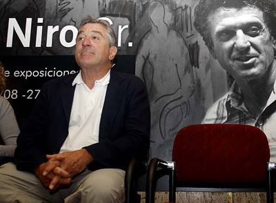 Robert de Niro, ayer en Bilbao en la inauguración de la exposición de su padre, ya fallecido, cuya foto se puede ver en el cartel.