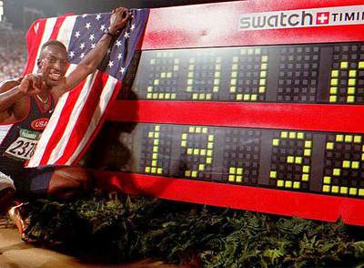 Michael Johnson, posa con la bandera estadounidense tras batir el récord mundial de 200m y ganar el oro en los Juegos de Atlanta 96.