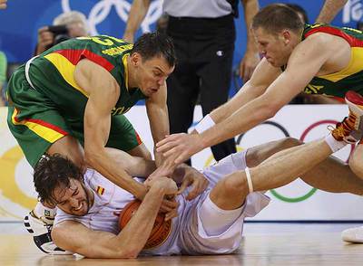 Pau Gasol, en el suelo, protege el balón que intentan arrebatarle Jasikevicius, a la izquierda, y Petravicius.