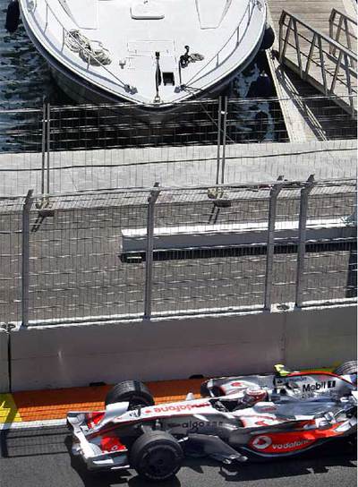 Hamilton pasa con un yate al fondo.