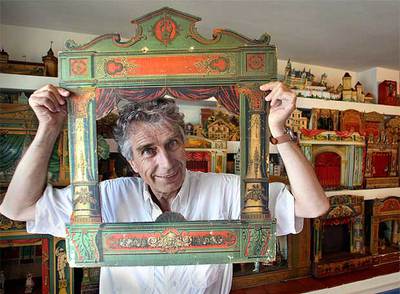 Francesc López Sala asoma la cabeza por una de las piezas de su colección, que inició de niño a golpe de regalos de los Reyes Magos.rn  pere duranrnLos cuentos infantiles protagonizan diversos teatrillos de época.  