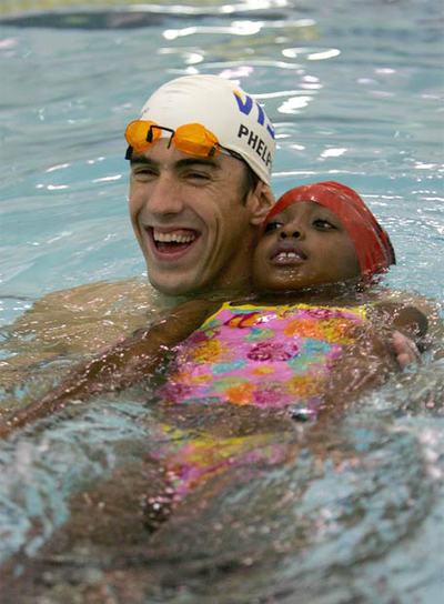 Michael Phelps participa en un programa para enseñar a nadar a niños ayer en Nueva York.
