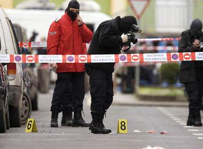  Ertzainas  fotografían la calle de Arrasate (Mondragón) en la que el ex concejal Isaías Carrasco recibió tres tiros el 7 de marzo.