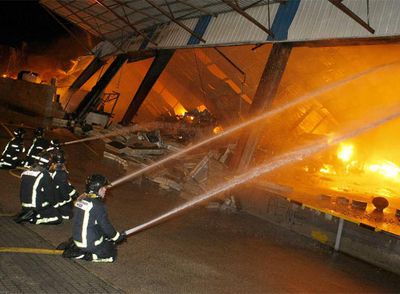 Los bomberos atacan las llamas en la nave de O Gorxal durante la madrugada de ayer.