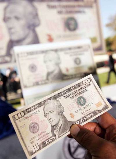 Un funcionario del Departamento del Tesoro muestra uno de los nuevos billetes de 10 dólares.