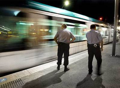 Dos vigilantes de seguridad inspeccionan, la madrugada del viernes al sábado, la estación del tranvía de Sant Adrià de Besòs.