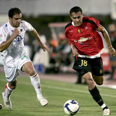 Arango conduce el balón perseguido por Cisma.