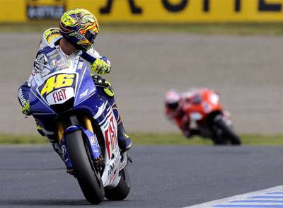 Valentino Rossi mira atrás, a Casey Stoner, durante la carrera de ayer en Motegi.