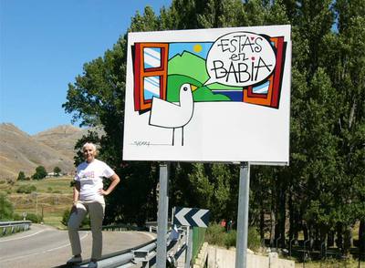 Retrato de la autora del texto, Cristina Fernández Pérez, frente a un cartel que anuncia la comarca  de Babia, en la montaña de León.