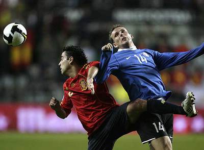 Xavi intenta cabecear el balón pese a la oposición de Vassilijev.