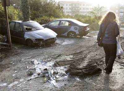 Estado en que quedaron dos vehículos aparcados al lado del coche incendiado.