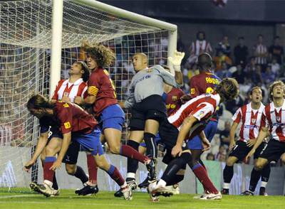 Víctor Valdés, el portero del Barcelona, salta rodeado de jugadores ante un balón aéreo.