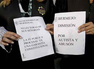Dos secretarias judiciales con toga muestran carteles contra Bermejo en la protesta de la Ciudad de la Justicia de Valencia.