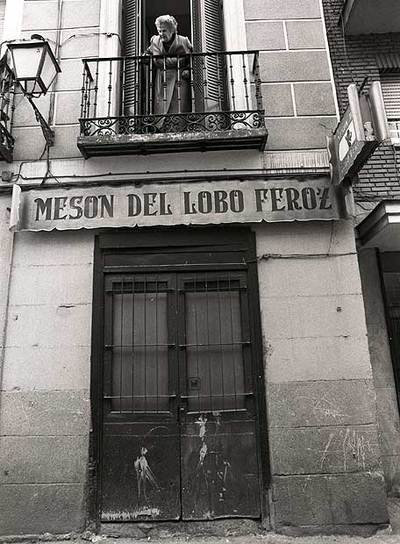 Una vecina se asoma al balcón justo encima del Mesón del Lobo Feroz.