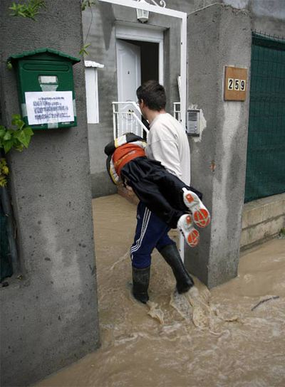 Un vecino de la avenida de Vicálvaro, en Coslada, entra con su hijo en su vivienda.