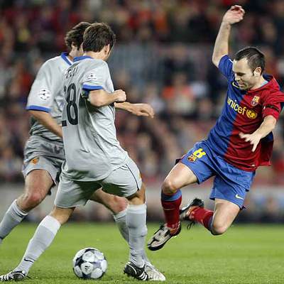 Iniesta pelea el balón ante dos jugadores del Basilea.