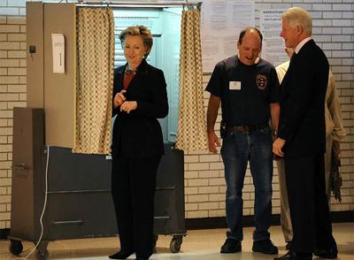 Hillary y Bill Clinton, bromean con un policía en su colegio electoral, en Nueva York.