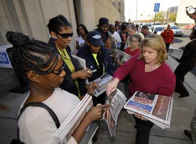Varios ciudadanos compran el miércoles en la sede de The Detroit News ejemplares de una edición extra.