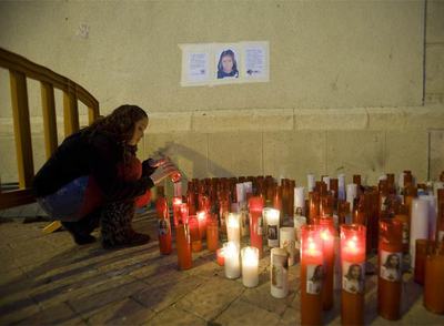 Una vecina enciende una vela en memoria de Leslie Estefanía en la Iglesia de Fortuna (Murcia).