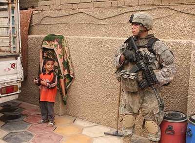 Un niño observa a un soldado estadounidense que patrulla en las calles de Ciudad Sáder, en Bagdad.