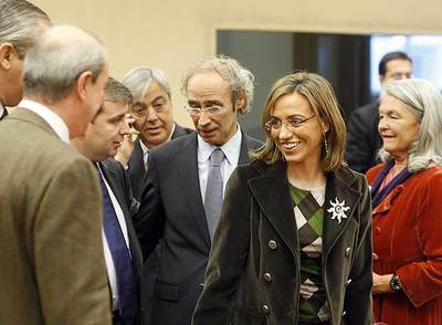 La ministra de Defensa, Carme Chacón, rodeada de varios diputados tras su comparecencia en la Comisión de Defensa del Congreso.